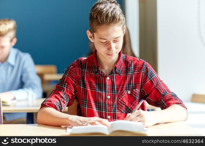 education, learning and people concept - group of students with books writing school test