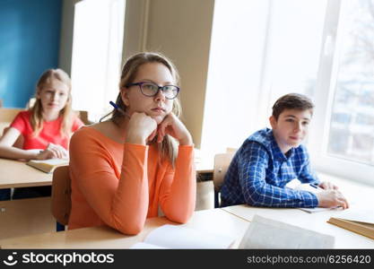 education, learning and people concept - group of students with notebooks at school lesson