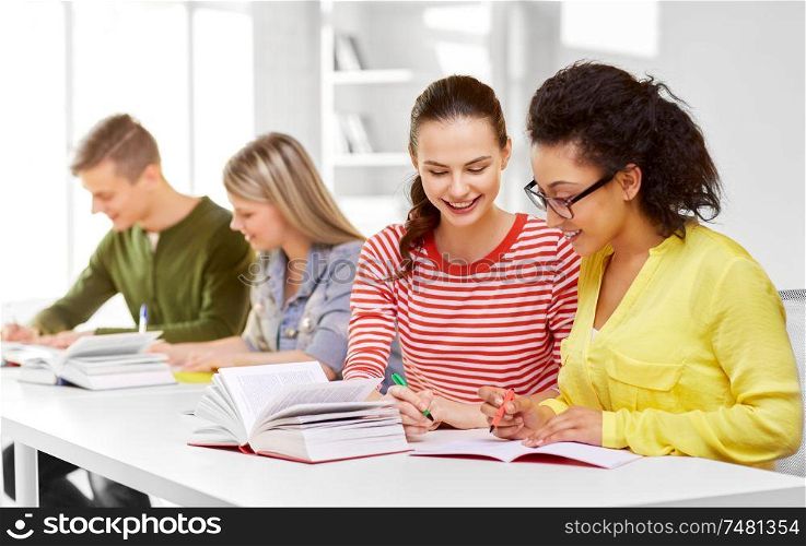 education, learning and people concept - happy high school student girls or classmates with books and notebooks. high school students with books and notebooks