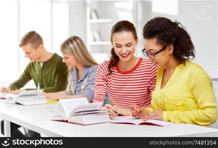 education, learning and people concept - happy high school student girls or classmates with books and notebooks. high school students with books and notebooks
