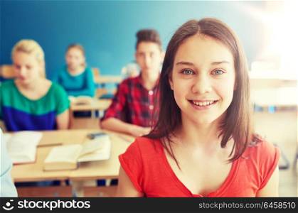 education, learning and people concept - happy student girl at school lesson. happy student girl at school lesson