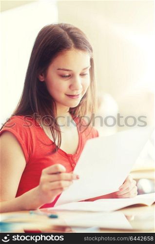 education, learning and people concept - happy student girl with test paper at school. happy student girl with test paper at school