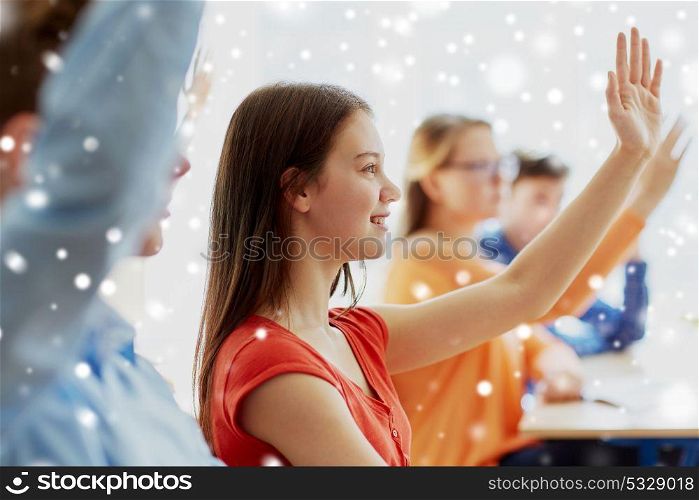 education, learning and people concept - student girl raising hand at school lesson over snow. student girl raising hand at school lesson
