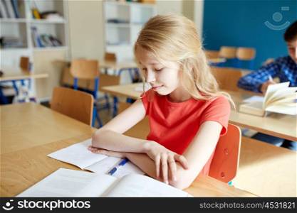 education, learning and people concept - student girl with book and notebook at school lesson