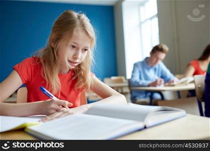 education, learning and people concept - student girl with book writing school test