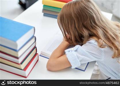education, learning, children and people concept - close up of student girl with many books at school desk
