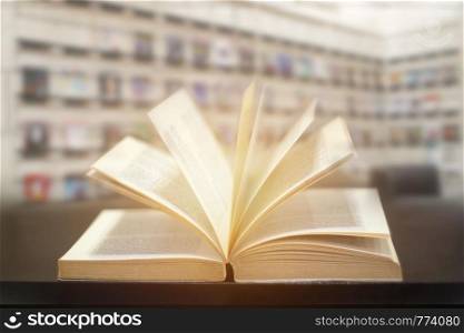 Education learning concept with opening book or textbook in modern library background.
