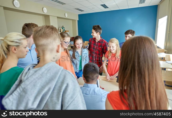 education, learning, teaching, technology and people concept - group of students and teacher with tablet pc computer at school