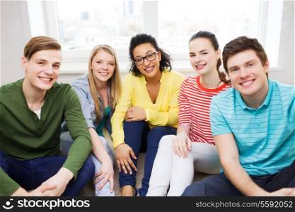 education, leisure and happiness concept - five smiling teenagers having fun at home