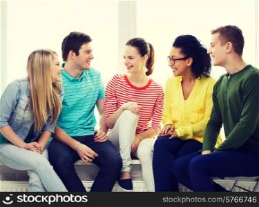 education, leisure and happiness concept - five smiling teenagers having fun at home or school