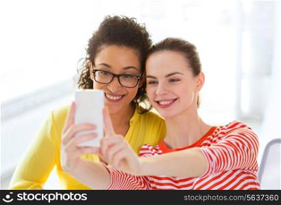 education, leisure and technology concept - two girlfriends taking selfie with smartphone camera
