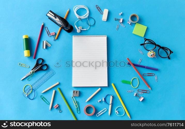 education, office and object concept - notebook and stationery or school supplies on blue background. notebook and school supplies on blue background