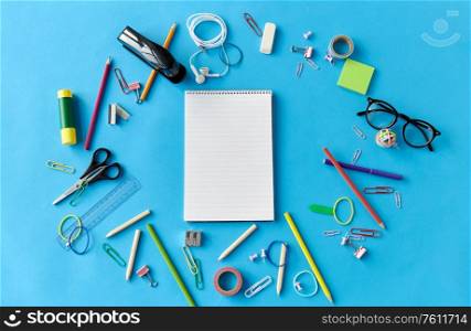 education, office and object concept - notebook and stationery or school supplies on blue background. notebook and school supplies on blue background