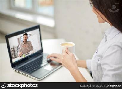 education, online school and distance learning concept - close up of woman with laptop watching tutorial video and drinking coffee at home. woman with laptop and coffee learning online
