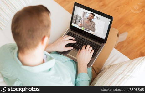 education, online school and distance learning concept - man with laptop watching tutorial video at home. man with laptop watching tutorial video at home