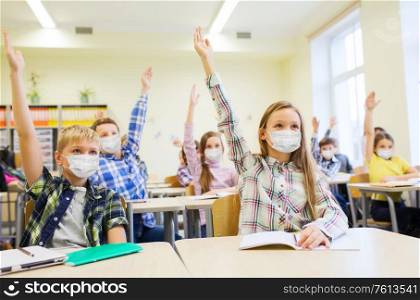 education, pandemic and health concept - group of students wearing face protective medical mask for protection from virus disease raising hands at school. group of students in masks raising hands at school