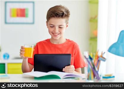 education, people and learning concept - happy student boy with tablet pc computer drinking orange juice at home. student boy with tablet pc and juice at home