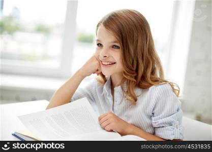 education, people, children and learning concept - happy student girl reading book at school