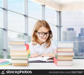 education, people, children and school concept - happy student girl in eyeglasses reading book at school over classroom background