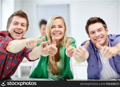 education, people, friendship and learning concept - group of happy high school students or classmates showing thumbs up