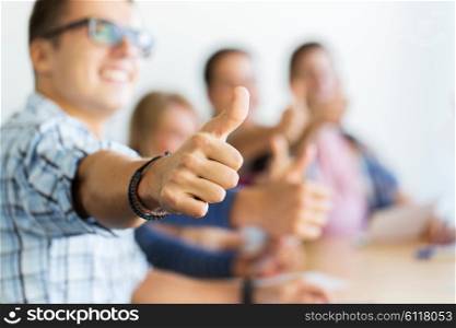 education, people, friendship and learning concept - group of happy high school students or classmates showing thumbs up