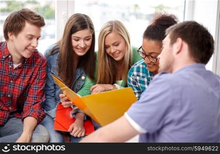 education, people, friendship and learning concept - group of happy international high school students or classmates with folders