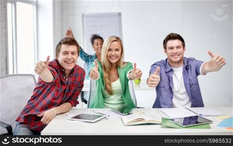 education, people, friendship and learning concept - group of happy international high school students or classmates showing thumbs up