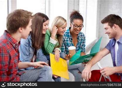 education, people, friendship and learning concept - group of happy international high school students or classmates with folders