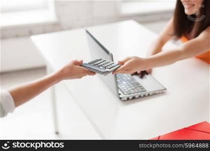 education, people, friendship, technology and high school concept - close up of female students with laptop sharing calculator at school