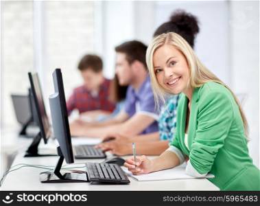education, people, friendship, technology and learning concept - group of happy high school students or classmates in computer class