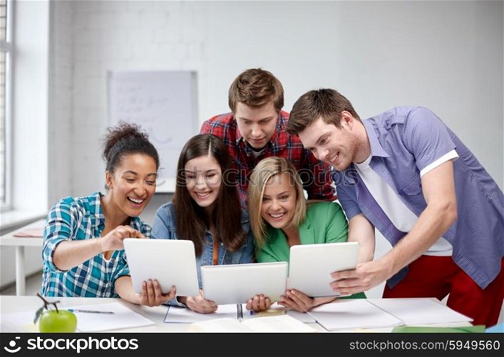 education, people, friendship, technology and learning concept - group of happy international high school students or classmates with tablet pc computer in classroom