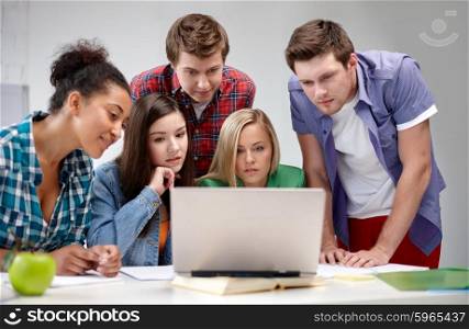 education, people, friendship, technology and learning concept - group of international high school students or classmates with laptop computer in classroom