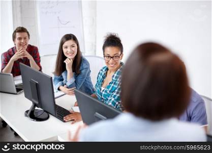 education, people, technology and learning concept - group of happy international high school students and teacher in computer class