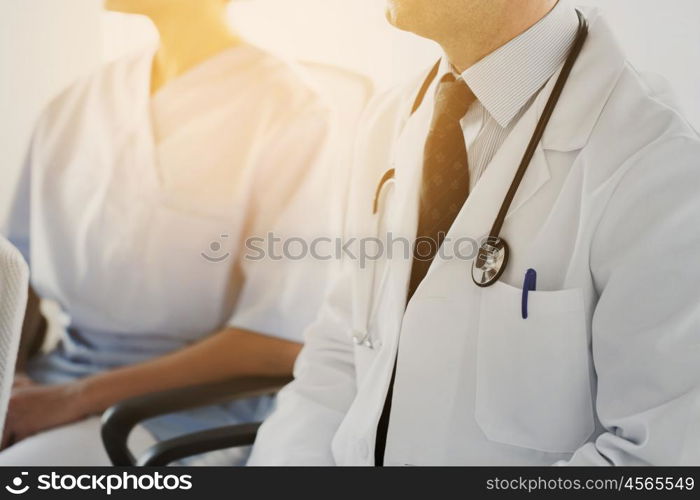 education, profession, people and medicine concept - close up of happy doctors at seminar or conference in hospital