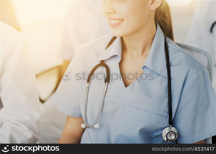 education, profession, people and medicine concept - close up of happy female doctor with stethoscope at seminar or hospital