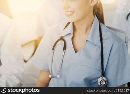 education, profession, people and medicine concept - close up of happy female doctor with stethoscope at seminar or hospital