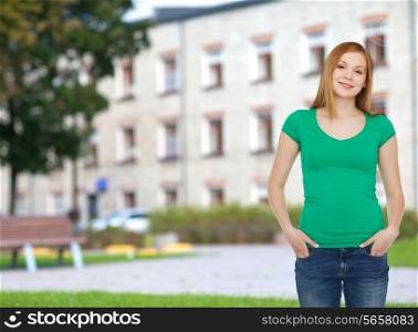education, school, advertisement and people concept - smiling teenage girl in casual clothes over campus background