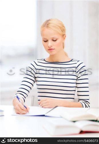 education, school and business concept - concentrated woman with books and notebook studying in college