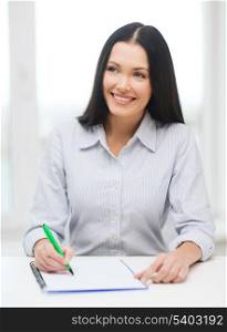 education, school and business concept - smiling businesswoman or student studying