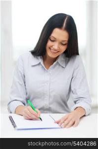 education, school and business concept - smiling businesswoman or student studying