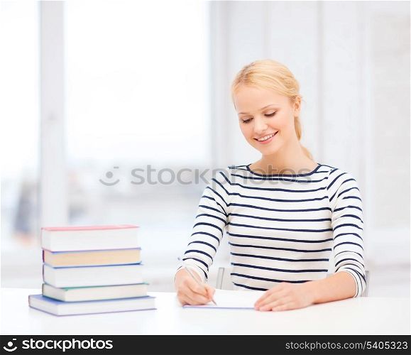 education, school and business concept - smiling woman with books and notebook studying in college