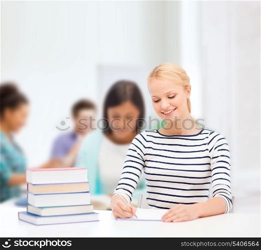 education, school and business concept - smiling woman with books and notebook studying in college