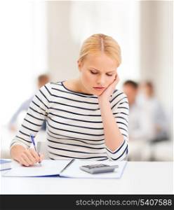 education, school and business concept - worried woman with notebook and calculator studying in college
