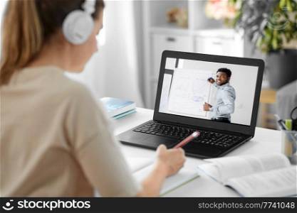 education, school and distant learning concept - female student woman with laptop computer having video call or online class with male teacher at home. student with laptop having video call with teacher