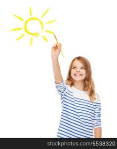 education, school and imaginary screen concept - cute little girl drawing sun with brush