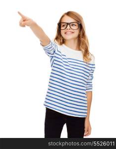 education, school and imaginary screen concept - cute little girl in eyeglasses pointing in the air or imaginary screen