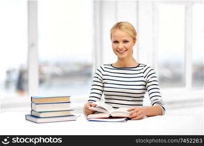 education, school and learning concept - smiling student woman with books at home. smiling student woman with books learning at home