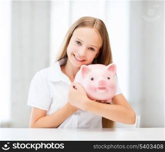 education, school and money saving concept - child with piggy bank