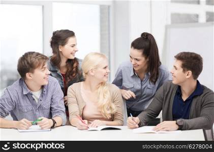 education, school and people concept - group of smiling students having discussion at school
