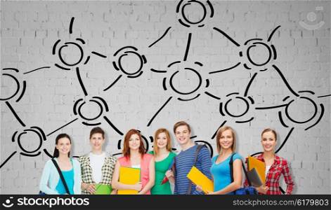 education, school and people concept - group of smiling teenage students with folders and school bags over gray brick wall background with network drawing